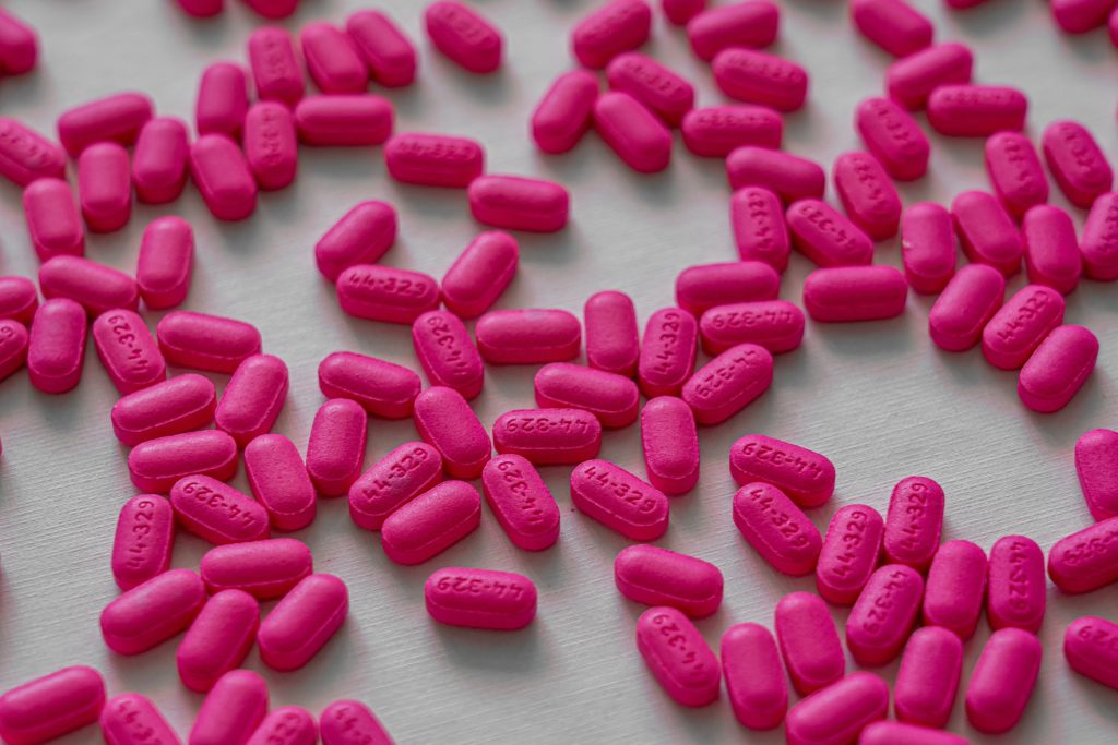 Розовые таблетки название. Розовые таблетки. Таблетки розового цвета. Розовые продолговатые таблетки. Темно розовые таблетки.